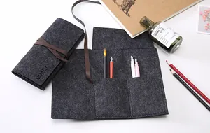 Vista dettagliata dell'astuccio in feltro grigio scuro con fessure per varie penne