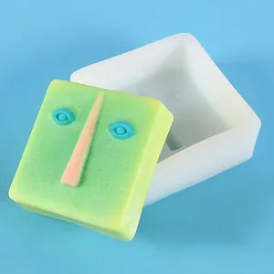 Close-up detail of square abstract face silicone mold and the finished plaster product.