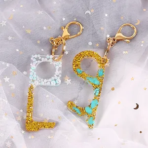 Close-up detail of DIY resin no-touch door opener keychains with glitter and stones.