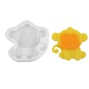 Detalle del molde de silicona con forma de mono y muestra de cera amarilla