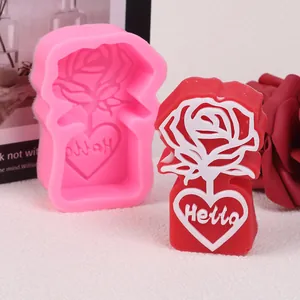Rose and heart patterned silicone mold next to a finished red wax scented candle.