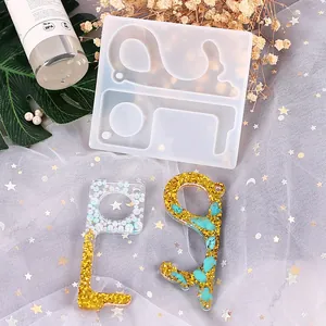 Detail view of a DIY silicone mold and finished glittery resin no-touch door opener tools.