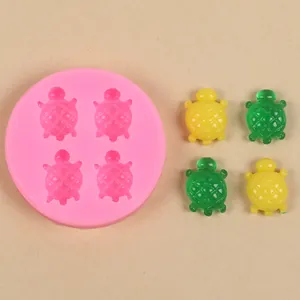 Detailopname van de roze siliconen schildpadvorm met gele en groene harsfiguren.
