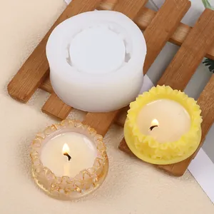 Detailed view of white silicone mold with finished floral wreath candle holder trays on wood
