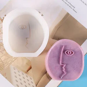 Detail view of abstract face silicone mold and textured purple plaster candle