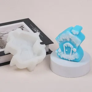 Detalle del molde de silicona casa de Navidad con vela de cabaña de nieve blanca y azulada