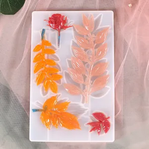Detalle de molde de silicona en forma de hoja con adornos florales de resina brillantes