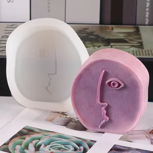 Detailed view of the abstract face silicone mold alongside a finished purple aromatherapy candle