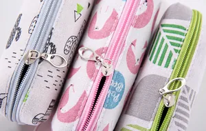 Close-up of colorful canvas pencil pouches with cartoon flamingo and cactus patterns