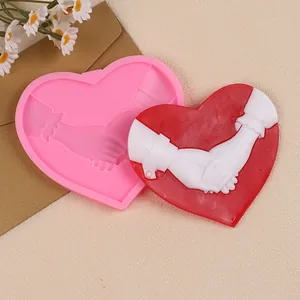 Detailed view of heart-shaped hand-holding silicone mold and finished resin craft