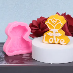 Detail of pink silicone mold and finished yellow rose candle with Love text engraving