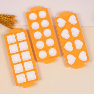 Top-down detail view of three orange kitchen molds in heart, round, and square shapes.