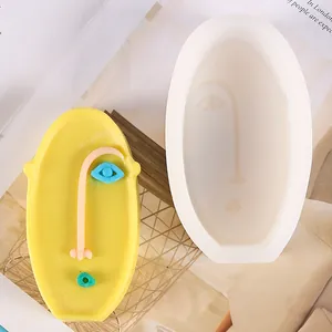 Detail of abstract face silicone mold with creative yellow gypsum candle ornament