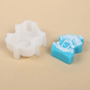 Molde de silicona para casa de Navidad que muestra el molde y la casa de cera azul