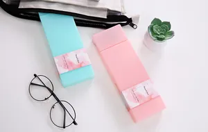 Minimalist candy-colored PP pencil cases with decorative paper sleeves and glasses