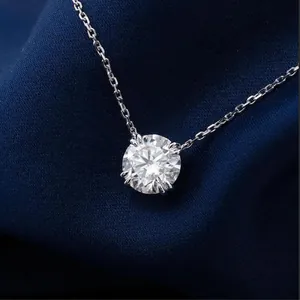 Close-up of a minimalist round-cut Moissanite solitaire necklace on blue fabric