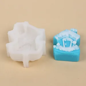 Vista detallada del molde de silicona y la vela de casa azul con nieve