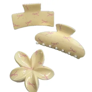 Set of 3 stylish cream-colored hair claw clips with cute pink bow patterns in various shapes