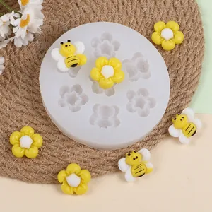Primer plano del molde de silicona con formas de abejas y flores de resina para manualidades DIY.