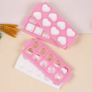 Pink and white plastic ravioli molds featuring heart, circle, and square patterns for baking