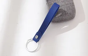 Close-up of a royal blue leather strap keychain with a polished silver metal ring