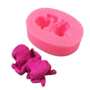 Detailed view of pink silicone sleeping baby mold and finished purple fondant resin figure
