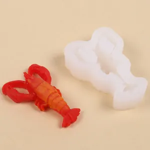 Detalle de un molde de silicona con forma de langosta y un modelo de langosta roja