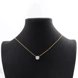 Close-up of a minimalist 14k gold-filled necklace with a round moissanite pendant on a mannequin.