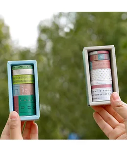 Close-up of vintage washi tape set in boxes held outdoors for journal DIY