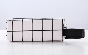 Detailed side view of a minimalist canvas pencil case with a black and white grid pattern.