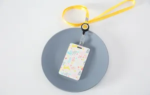 Primer plano de portatarjetas floral con cordón retráctil amarillo en un plato.