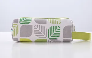 Detailed view of a simple canvas pencil case featuring a green leaf pattern and handle