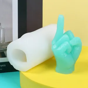 Vue détaillée d'un moule en silicone 3D en forme de majeur avec un échantillon en cire verte.