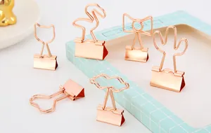 Detailaufnahme von roségoldenen kreativen Büroklammern in Kaktus- und Flamingo-Designs