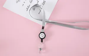 Primer plano de un cordón gris retráctil con un diseño de carrete de placa con carita sonriente