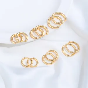 Detail showing various sizes of gold plated stainless steel hoop earrings on white cloth