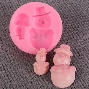 Primer plano de molde de silicona de muñeco de nieve rosa con figuras de fondant