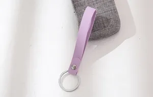 Close-up of a minimalist purple leather keychain with silver rivet and ring detail.