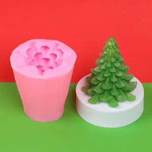 Detailansicht einer rosa Silikonform und einer fertigen grünen Weihnachtsbaumkerze auf Ständer.