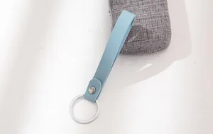 Close-up view of a light blue leather strap keychain with a polished silver ring
