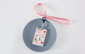 Detalle del porta tarjetas con flores, cordón rosa y clip de carrete retráctil suave.