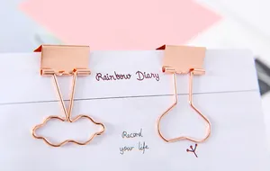 Detailansicht von roségoldenen Metallklammern in Wolken- und Herzform für Schreibwaren
