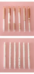 Detailed close-up of aesthetic retractable gel pens with various brown and white patterns