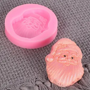 Detalle de un molde de silicona rosa de Papá Noel con una pieza de decoración terminada