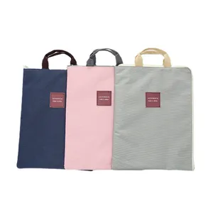Three minimalist waterproof laptop bags in navy, pink, and grey colors