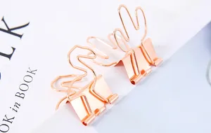 Detailansicht von kreativen roségoldenen Metallklammern in Flamingo- und Kaktusform