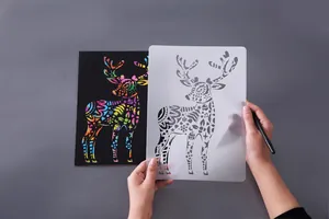 Close-up detail showing a reusable reindeer stencil with rainbow scratch art paper