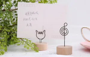 Detailed view of vintage wooden base wire memo clips in cat and musical note shapes.