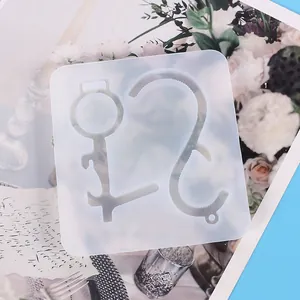 Clear silicone mold for DIY no-touch keychain tools on artistic floral background.