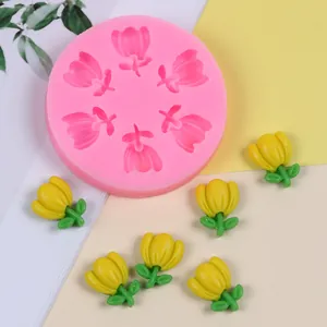 Detailed view of a pink tulip silicone mold alongside finished yellow flower resin shapes